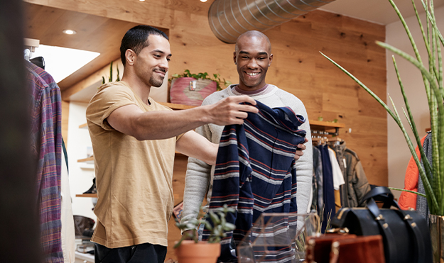 Two men checking out a shirt while shopping