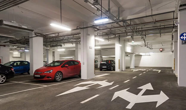 Red, blue, and black cars in a parking garage